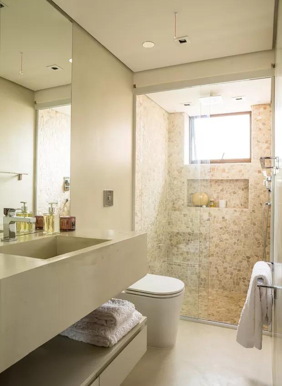 banheiro bege com revestimento 3d na parede do chuveiro 2