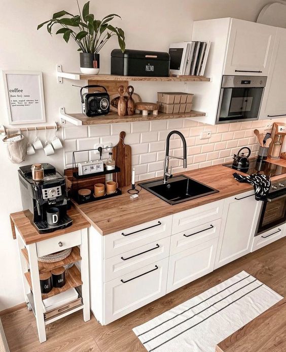 cozinha com armários brancos e bancada de madeira